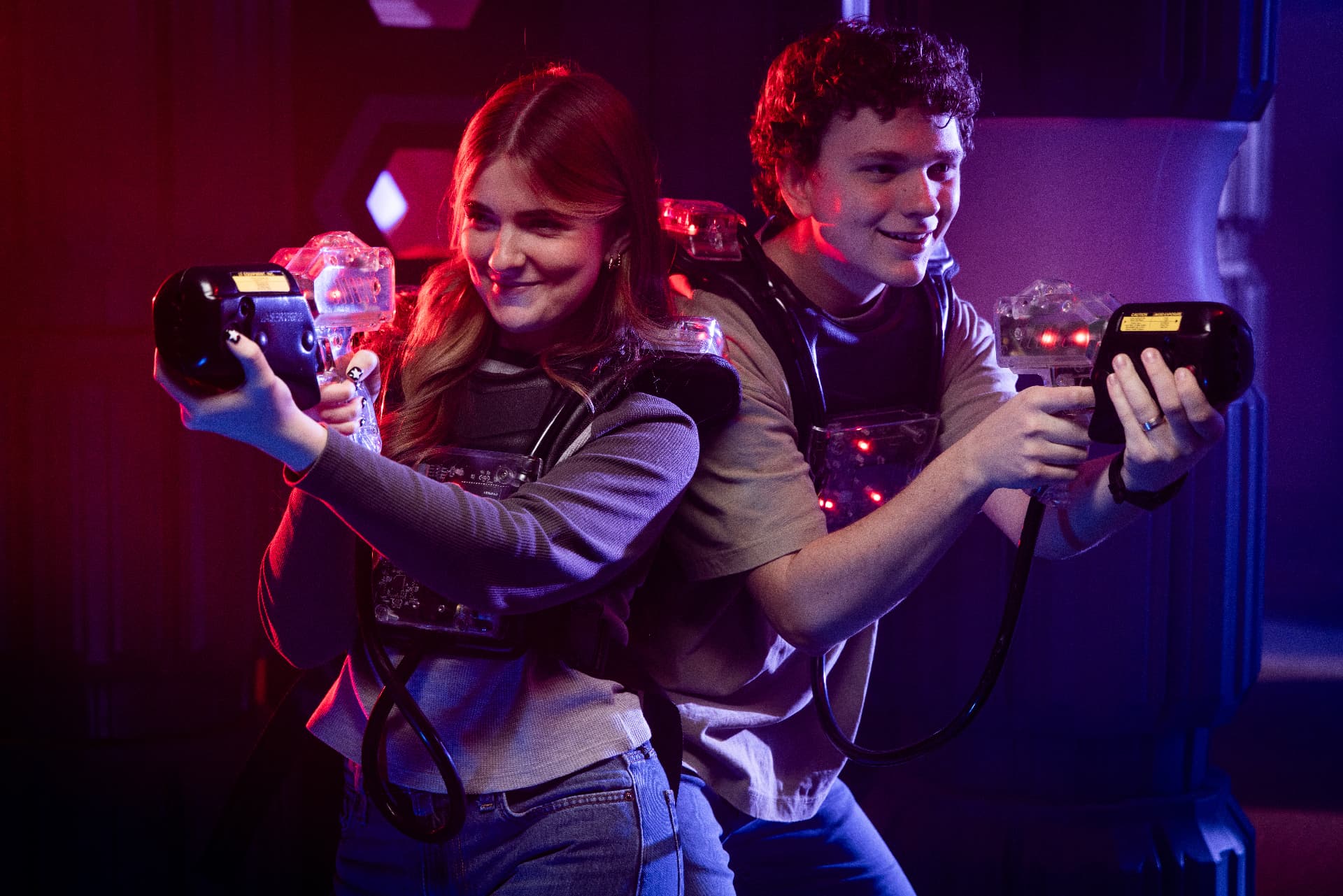 Two players aiming laser tag phasers in the Rad Tag arena